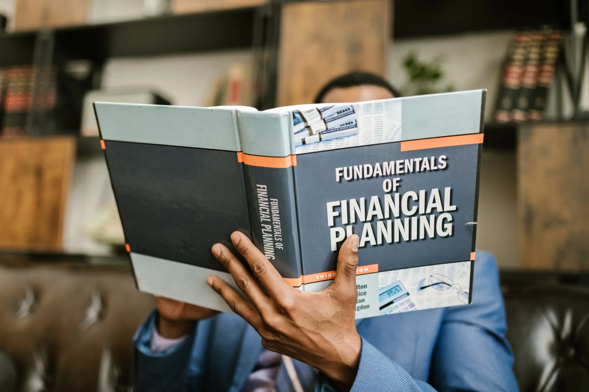 A man is reading a book about financial planning.